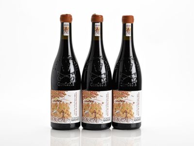 three bottles of wine sitting next to each other on a white surface