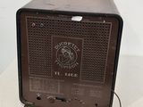 an old radio sitting on top of a table next to a white wall
