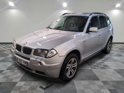 une photo d'un SUV BMW argenté posé sur un sol à damier