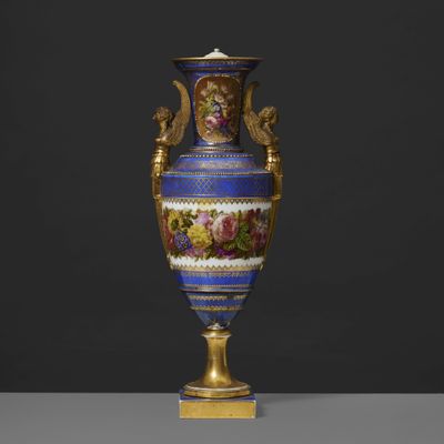 un vase bleu richement décoré, orné de bordures dorées et de motifs floraux
