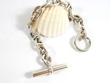 silver plated bracelet with a shell charm and a key