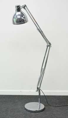 un lampadaire argenté surmonté d'un abat-jour noir