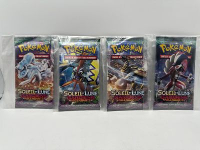 Trois paquets de cartes à collectionner Pokémon sont posés sur une table