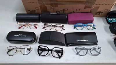 une table sur laquelle se trouvent des verres, un étui à lunettes, des lunettes et d'autres objets