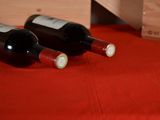 two bottles of wine sitting on a red table