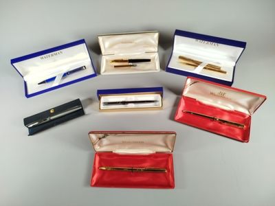 six different pens and a case are sitting on a table