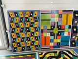 several pieces of art on display in a room with a large window