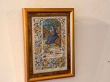 three framed pictures on the wall above a toilet