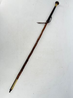 an old cane with a wooden handle on a white surface