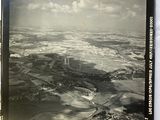 an old black and white photo of an airplane flying over a field
