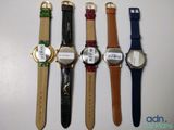 four watches are lined up in a row on a white surface