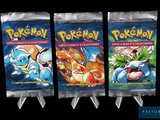 trois paquets de cartes Pokémon exposés sur un fond noir