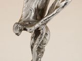 une figurine en argent représentant un joueur de baseball tenant une batte