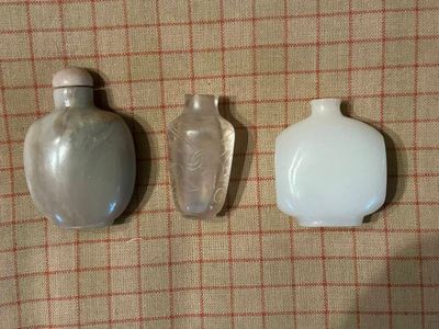 trois bouteilles en verre posées les unes à côté des autres sur une table