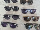 several pairs of sunglasses are on a table with a price tag