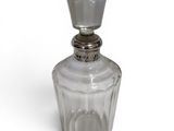 an image of a clear glass bottle with a metal stopper