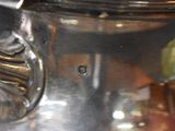 a close up of a silver tea pot on a table
