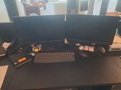 a desk with two computer monitors and a keyboard on it
