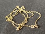 a close up of a gold chain with a heart charm on it