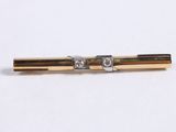 a picture of a gold and diamond tie bar on a white background