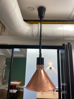 a copper lamp hanging from the ceiling in a room