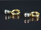 paire de boucles d'oreilles en or et perles sur fond noir avec reflets