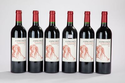 quatre bouteilles de vin rouge sont alignées