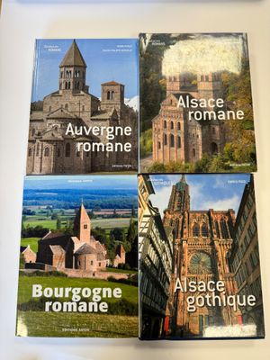 trois livres posés sur une table, à côté d'une tasse de café et d'un téléphone portable