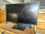 a computer monitor sitting on top of a wicker table