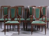 set of six chairs with green upholstered seats in a room