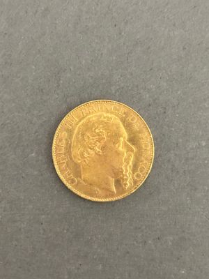 a close up of a gold coin on a gray surface