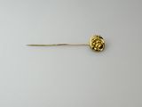 a close up of a gold pin with a flower on it