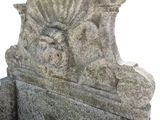 a stone bench that has a lion head on it