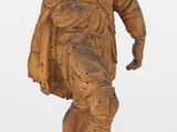 statue en bois représentant un homme portant un chapeau et une cape