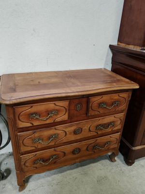 une commode en bois surmontée d'un miroir