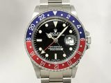 a rolex watch with a red, blue and red bezel