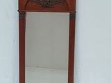 un petit miroir accroché au mur, à côté d'un mur blanc
