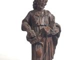statue d'un homme coiffé d'un chapeau et vêtu d'une robe, tenant un livre