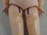 a doll that is sitting on the floor next to a wall