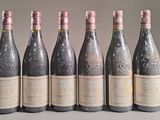 six bottles of wine are lined up in a row on a table