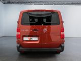the back of a red van parked inside of a building