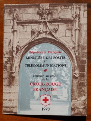brochure de la Croix-Rouge française posée sur une table en bois devant un bâtiment