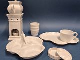une photo d'un service en porcelaine comprenant une théière, une soucoupe, des tasses et des soucoupes