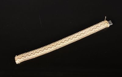 gros plan d'un bracelet en or sur une surface noire