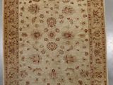 a beige and brown rug with a floral design on it