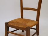 a wooden chair with a wicker seat on a white background