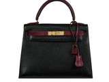 a black and burgundy leather handbag with gold hardware