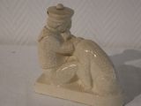 a small figurine of a man sitting on a pillow