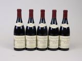 six bottles of wine are lined up on a white surface