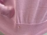 a close up of a pink sweater with buttons on it